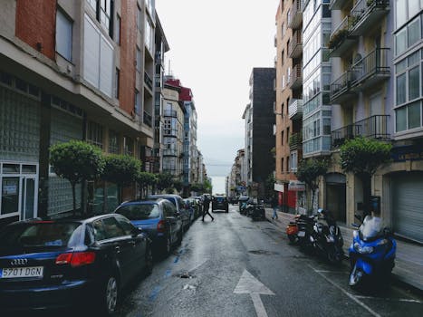 西班牙桑坦德的城市街道在雨天以建筑和车辆为特色