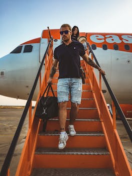 Casual travelers descending stairs from an EasyJet airplane, capturing a travel moment.