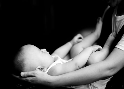 Black and White Photo of Baby Held by Parent
