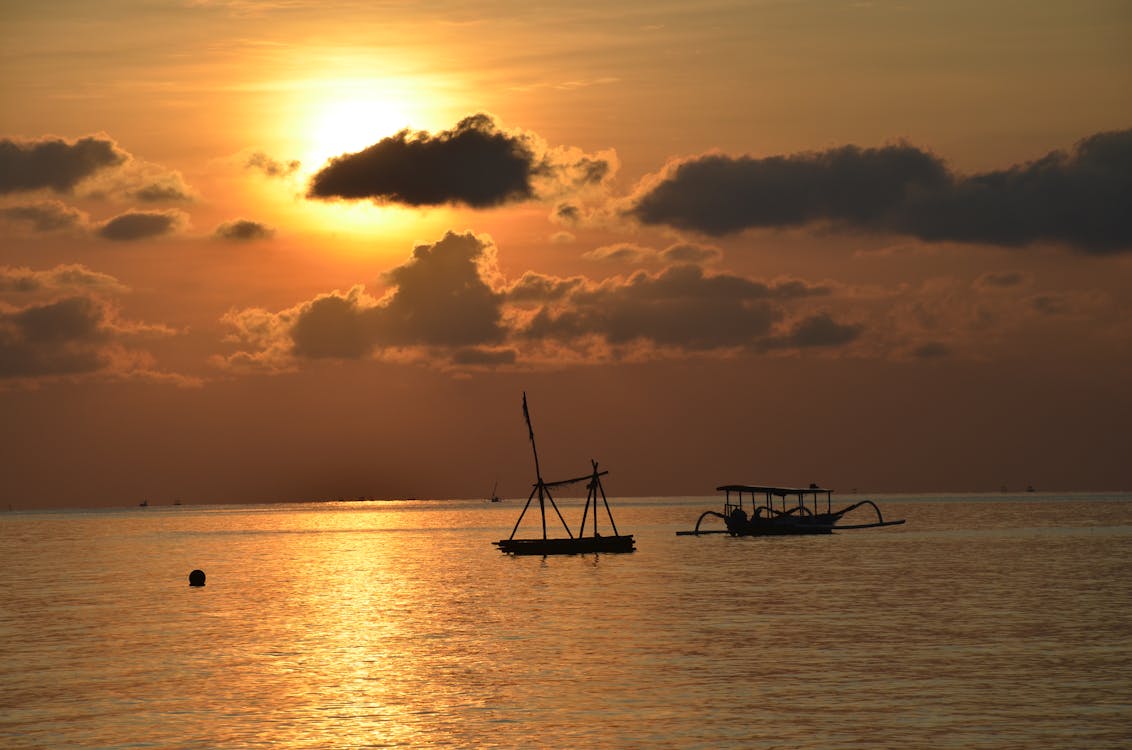 Silhouette of Boats on a Sea during Sunset 