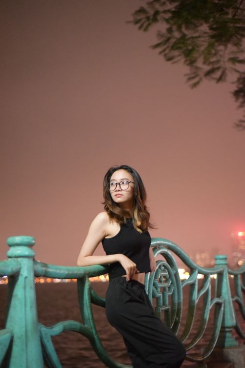 Woman in Black Tank Top with Eyeglasses Leaning on a Metal Railing ...