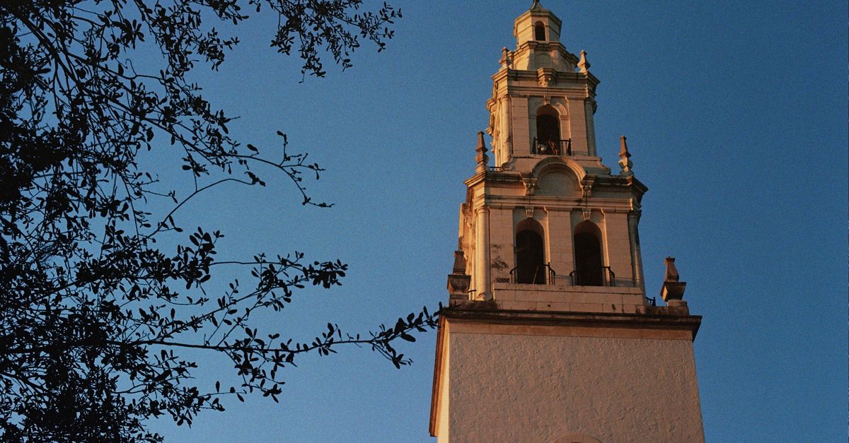 Low angle shot of Knowles Memorial Chapel tower with clear blue sky in Winter Park, FL.