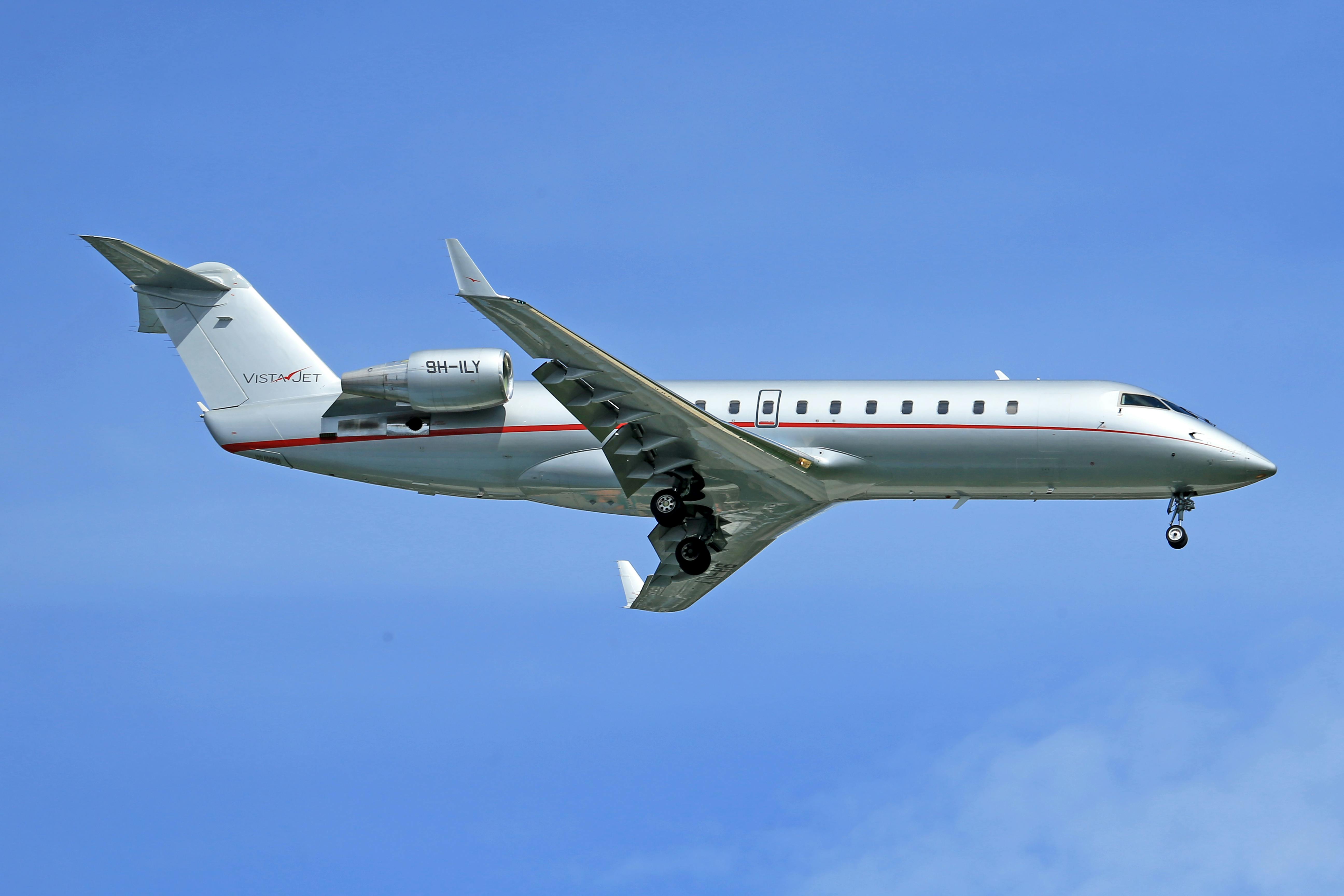 A sleek private jet flying high in a clear blue sky, showcasing modern aviation technology.