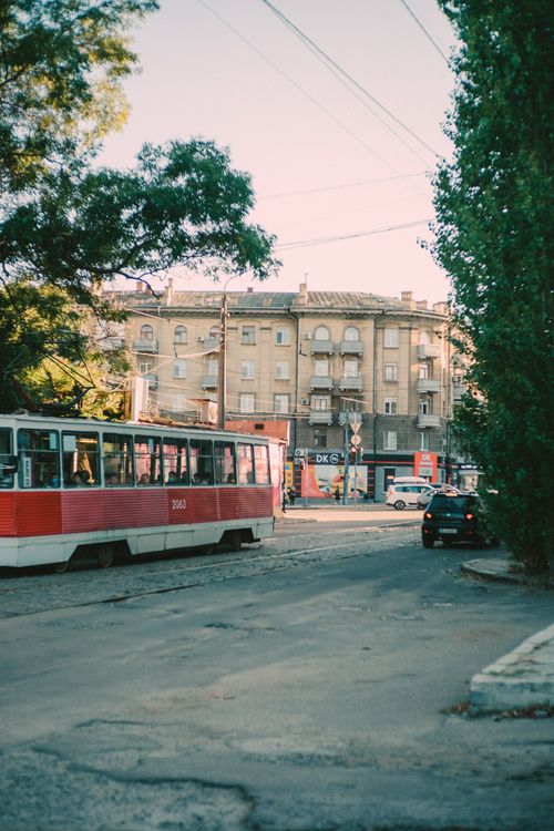 Free Vintage tram passing through a city street lined with historic buildings during the day. Stock Photo
