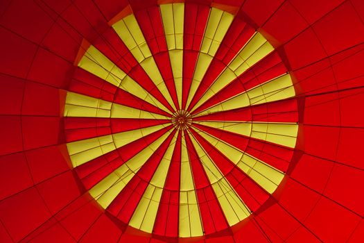 Close-up view of a red and yellow hot air balloon canopy creating a vibrant pattern.