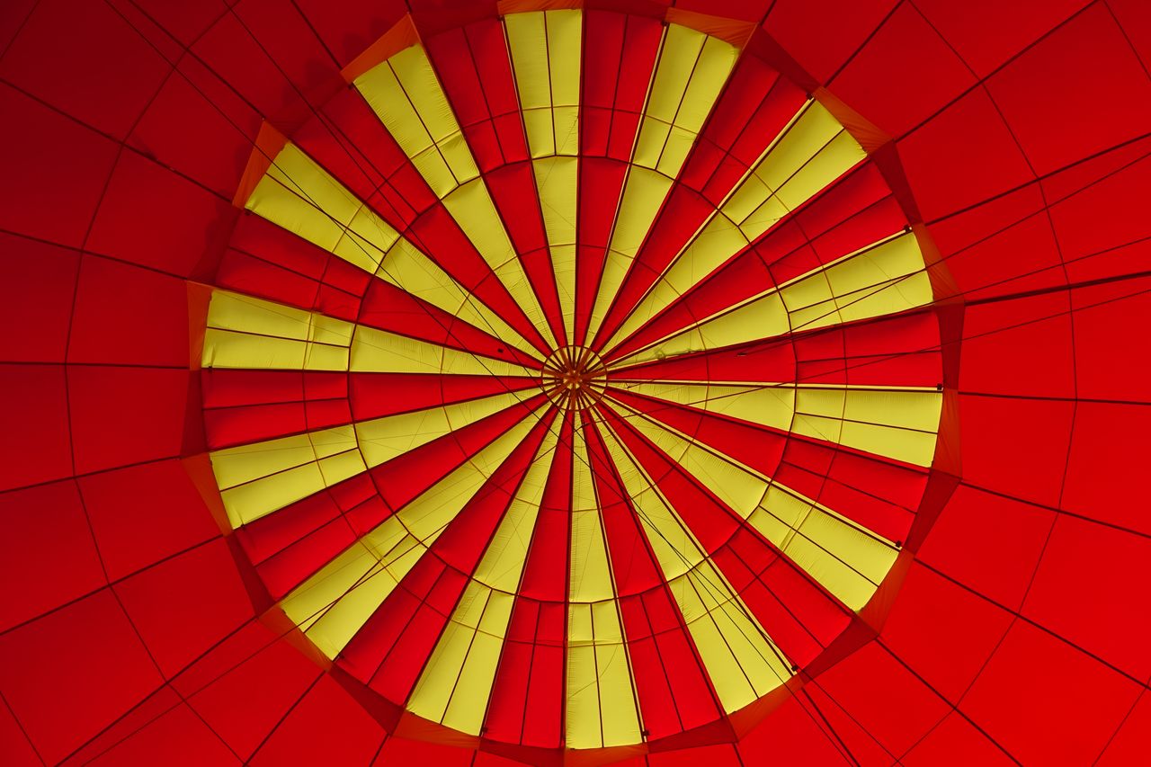 close up view of a red and yellow hot air balloon canopy creating a vi