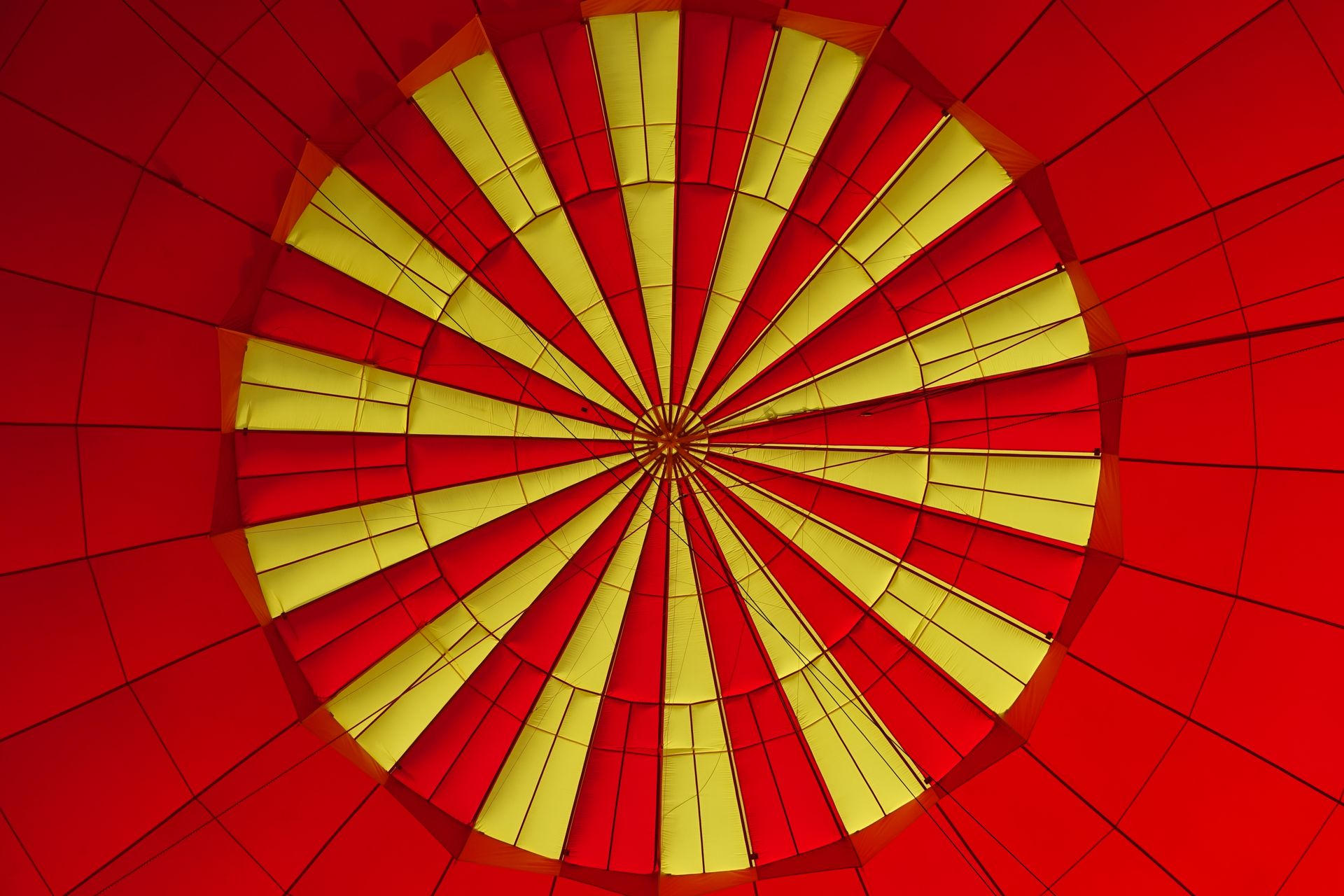 Close-up view of a red and yellow hot air balloon canopy creating a vibrant pattern.
