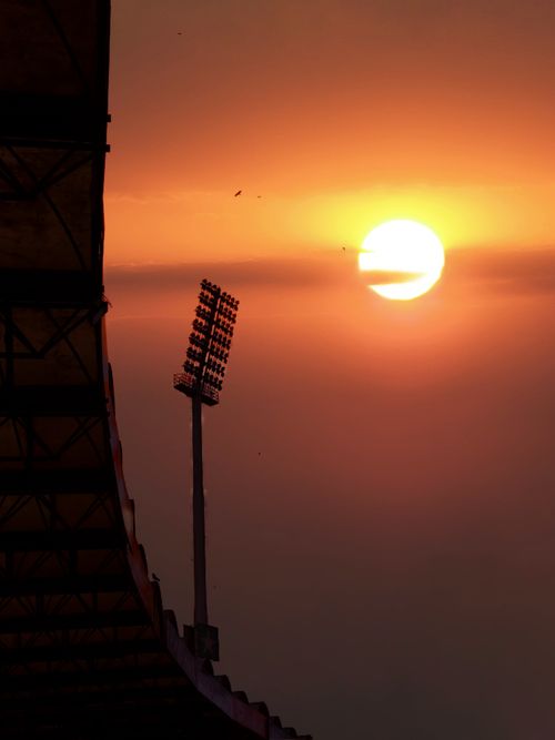 Free Silhouetted metal post against a stunning golden sunset at Ghadafi Stadium, Lahore. Stock Photo