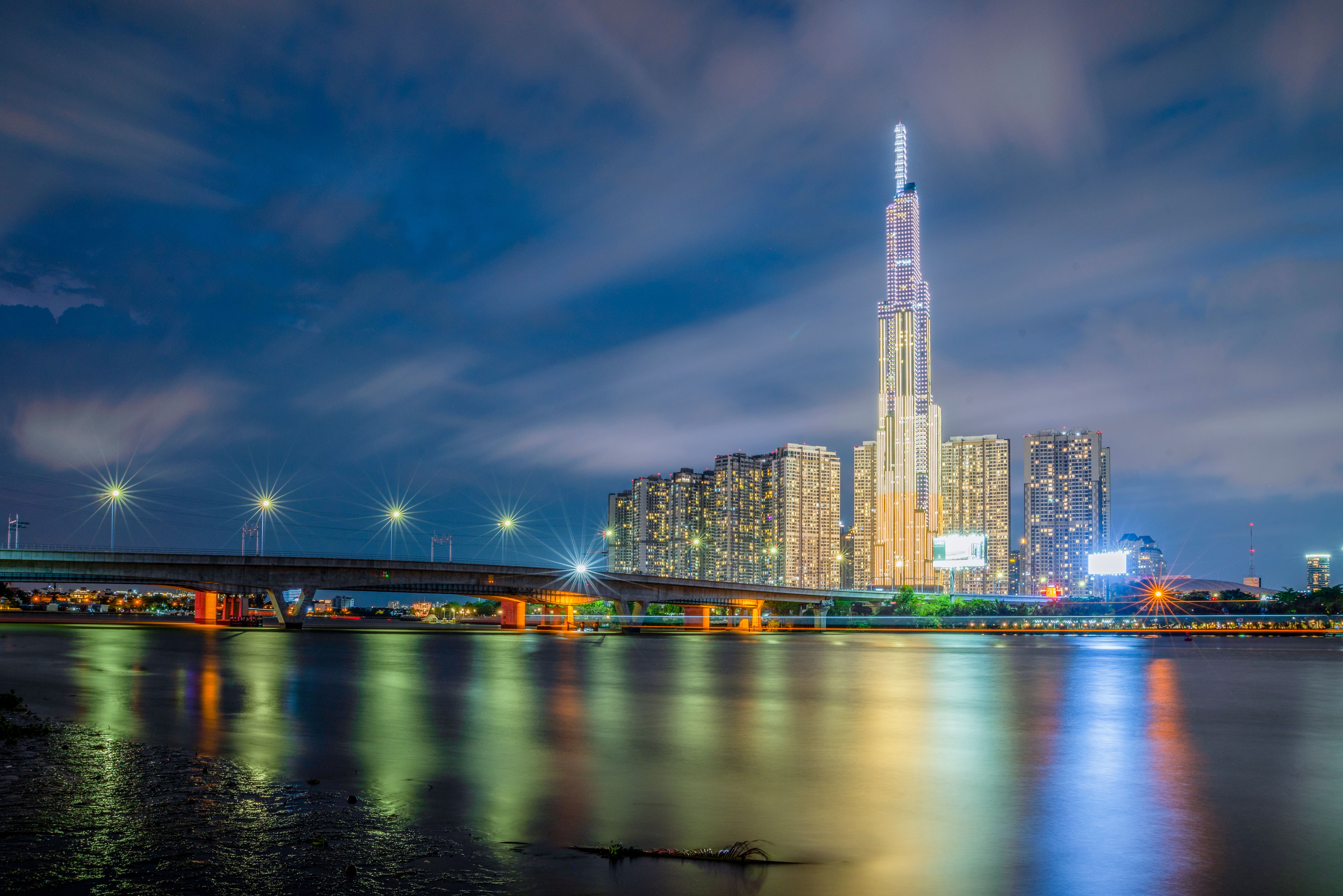 Long exposure nighttime view of Landmark 81 and cityscape reflections in Ho Chi Minh City, Vietnam.