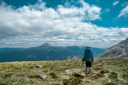 Free Backpacker exploring scenic Carpathian Mountains in Ukraine under a blue sky. Stock Photo