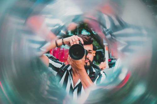 Free Artistic reflection of a photographer with a camera in a unique circular view. Stock Photo