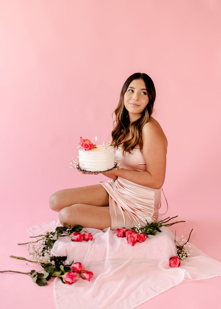 Woman Sitting On The Floor While Holding A Cake