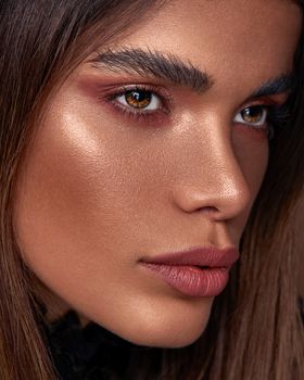 Stunning close-up portrait of a woman showcasing bold eye makeup and defined features.