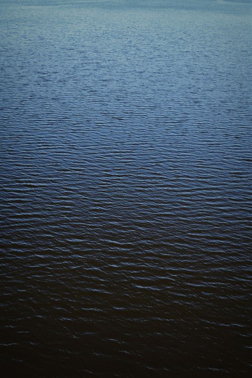 Free Serene aerial view capturing the calm sea with gentle ripples creating a natural texture. Stock Photo