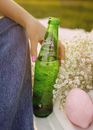 Green Glass Bottle on White and Gray Pebbles