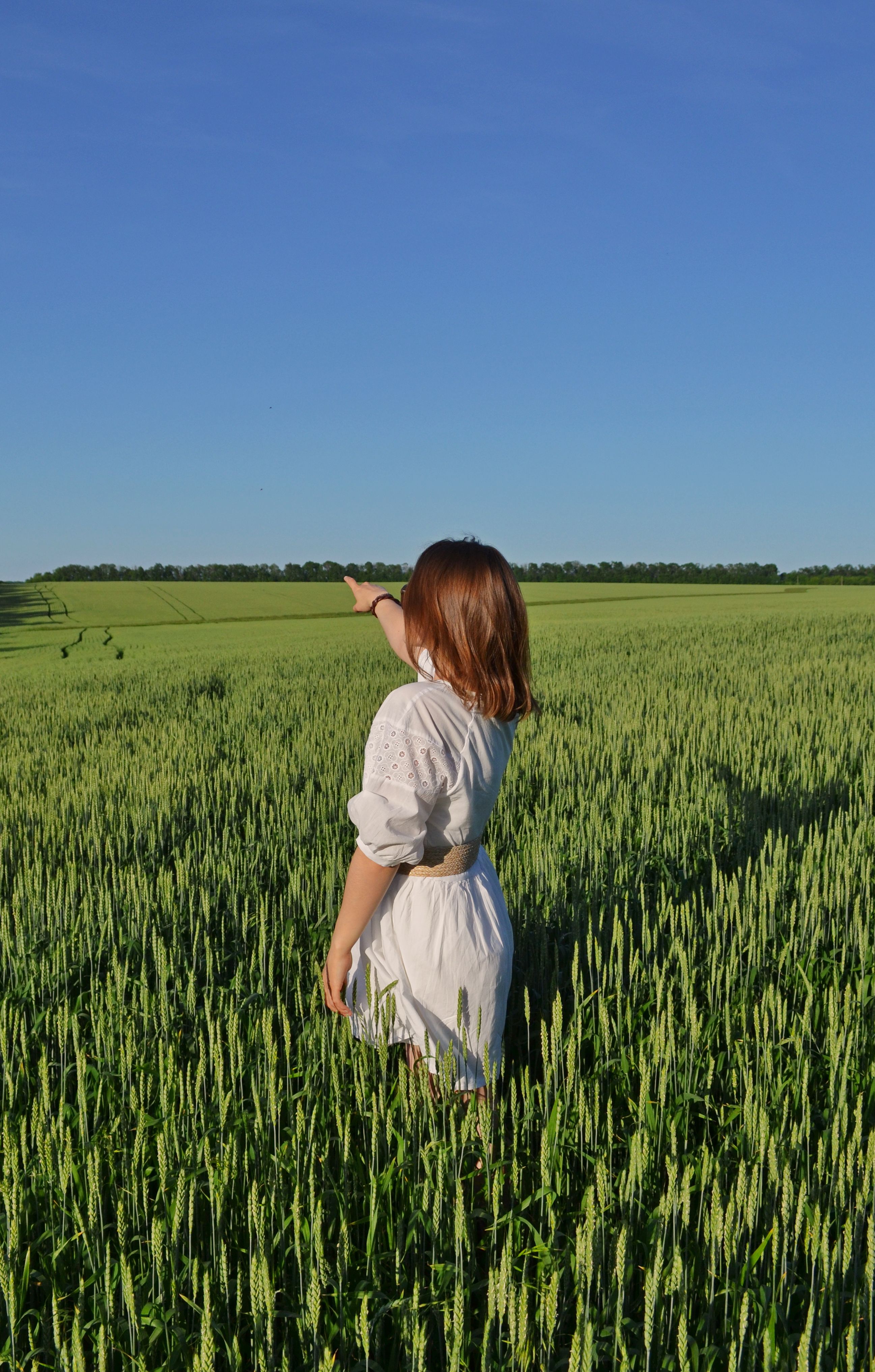 Person in Mustard Hoodie Standing on Green Grass Field · Free Stock Photo