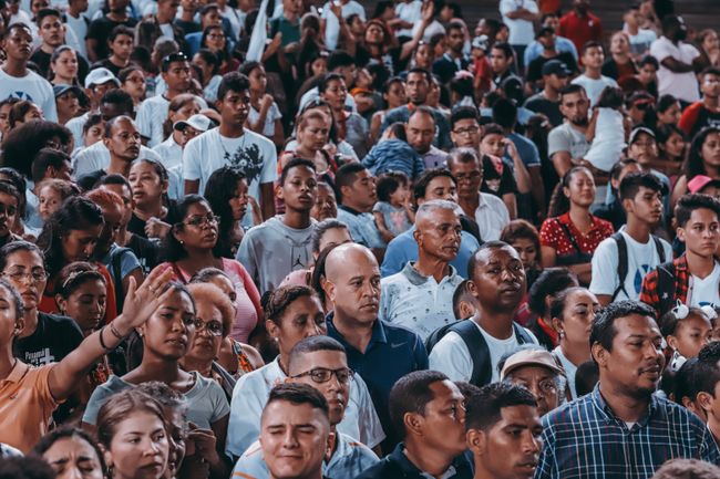 A large crowd gathered outdoors. Photo by Luis Quintero on Pexels
