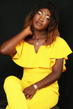 Elegant portrait of a woman in a vibrant yellow outfit, exuding confidence and fashion sense.