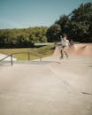Man in White T-shirt and Blue Shorts Riding Skateboard