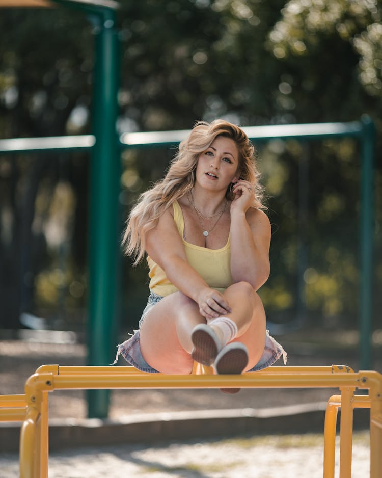 Woman Sitting On Monkey Bars