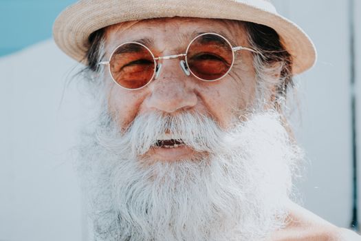 Portrait of an Elderly Man with Long Gray Beard, in a Hat and Sunglasses