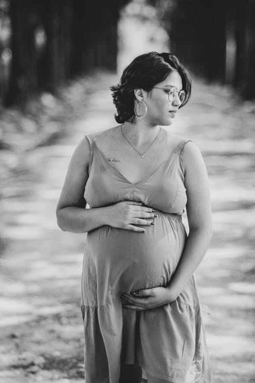 Pregnant Woman Holding Her Belly in Grayscale Photography