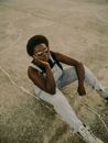 Woman in Sunglasses Sitting on Ground