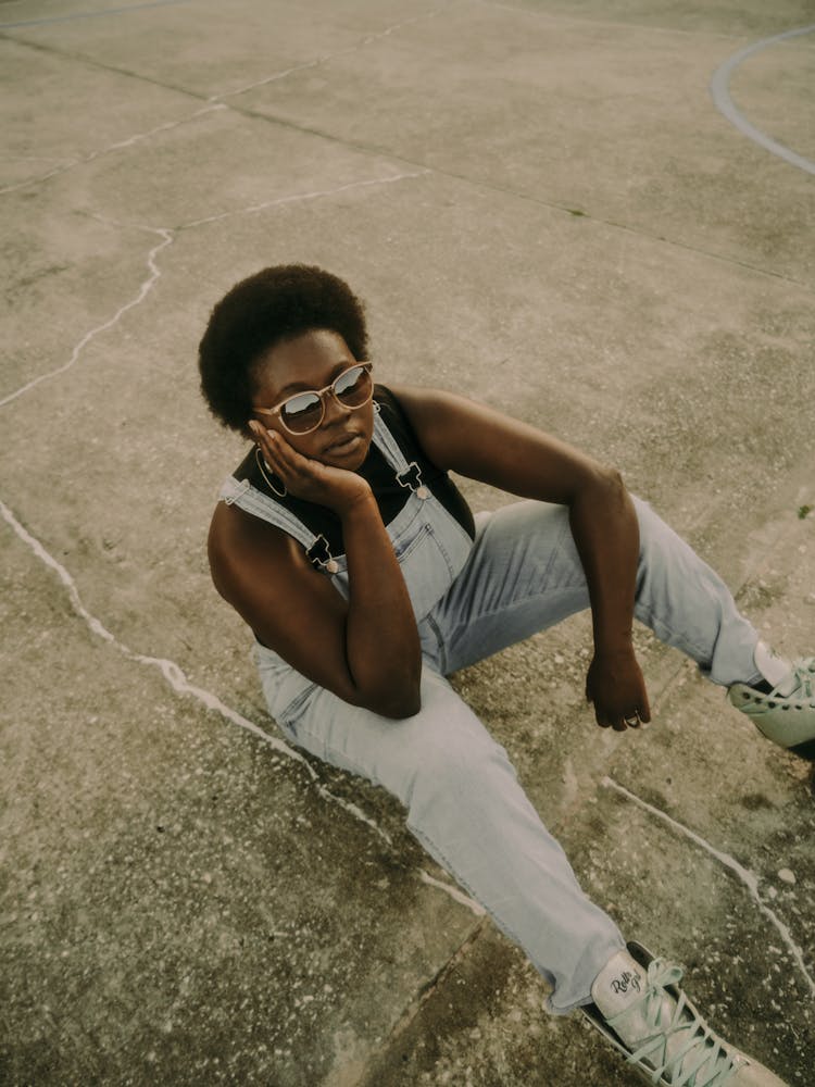 Woman In Sunglasses Sitting On Ground