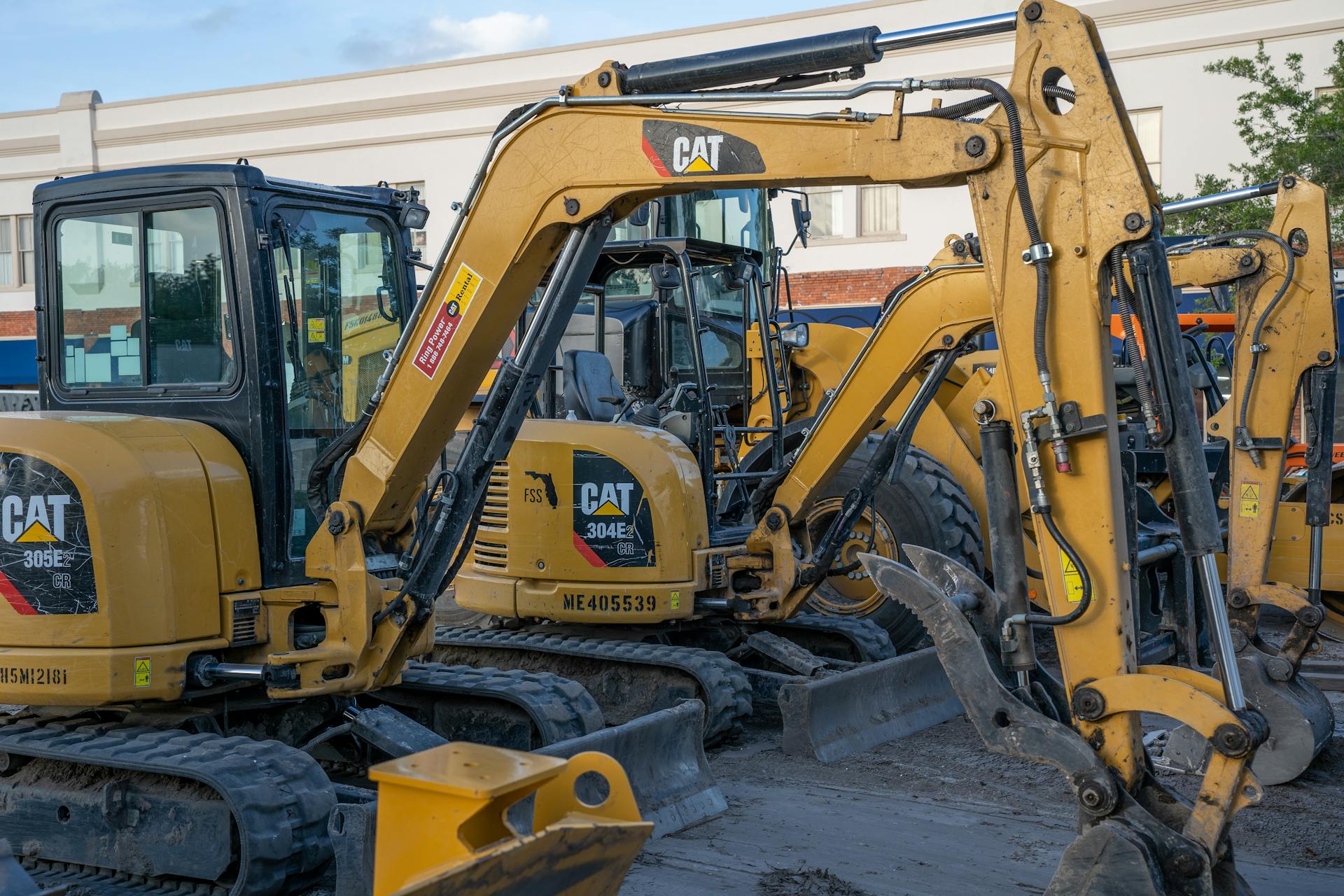 A row of parked excavators at a construction site, ready for heavy duty work.