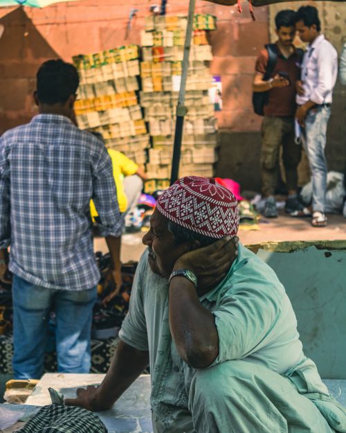 Free Street scene of a vendor in traditional attire at a busy New Delhi market. Stock Photo