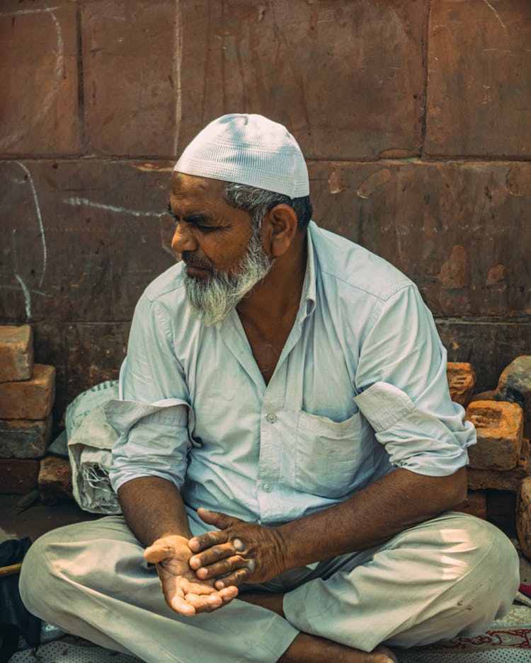 Bearded Man Sitting Cross Legged On Ground