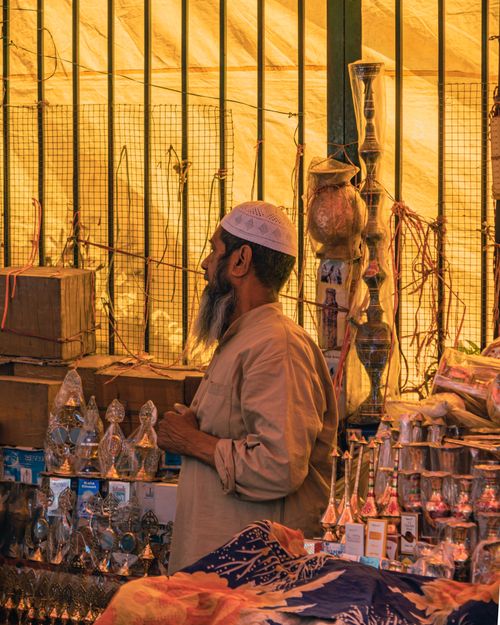 Free Bearded man wearing kufi at a vibrant market stall in New Delhi. Captured in a side view, showcasing the bustling atmosphere. Stock Photo