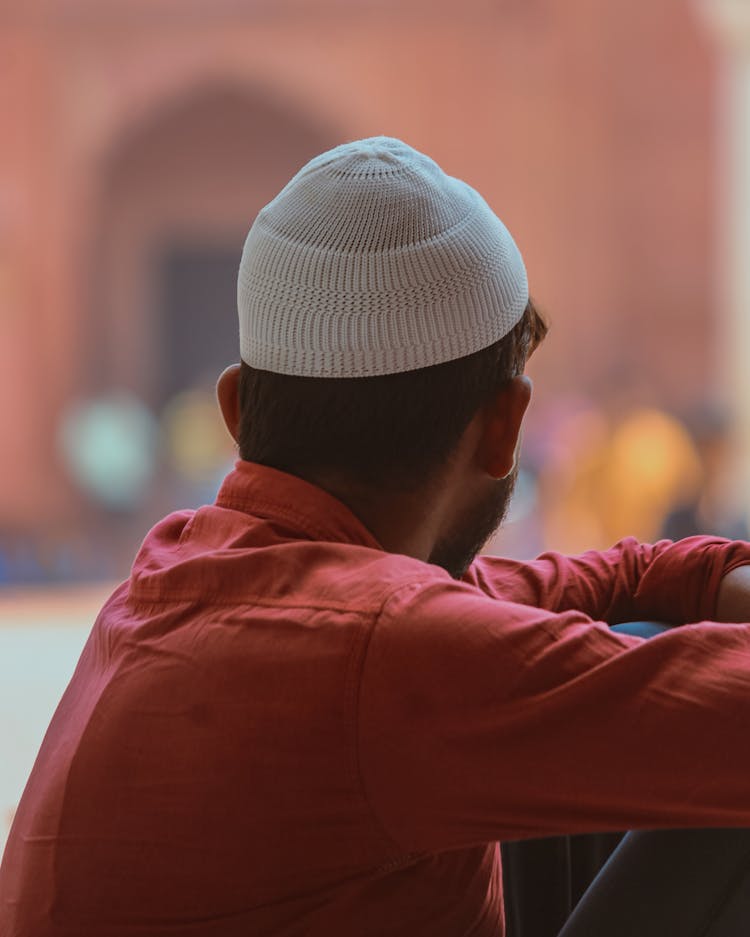 Man In Orange Long Sleeve Shirt  Wearing White Kufi Hat