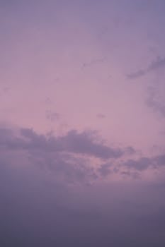 Beautiful purple twilight sky with scattered clouds, perfect for serene backgrounds.