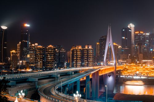Free Captivating view of Chongqing skyline with the illuminated Dongshuimen Bridge crossing the river at night. Stock Photo