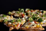 A veggie Pizza of a fast food restaurant an a black background