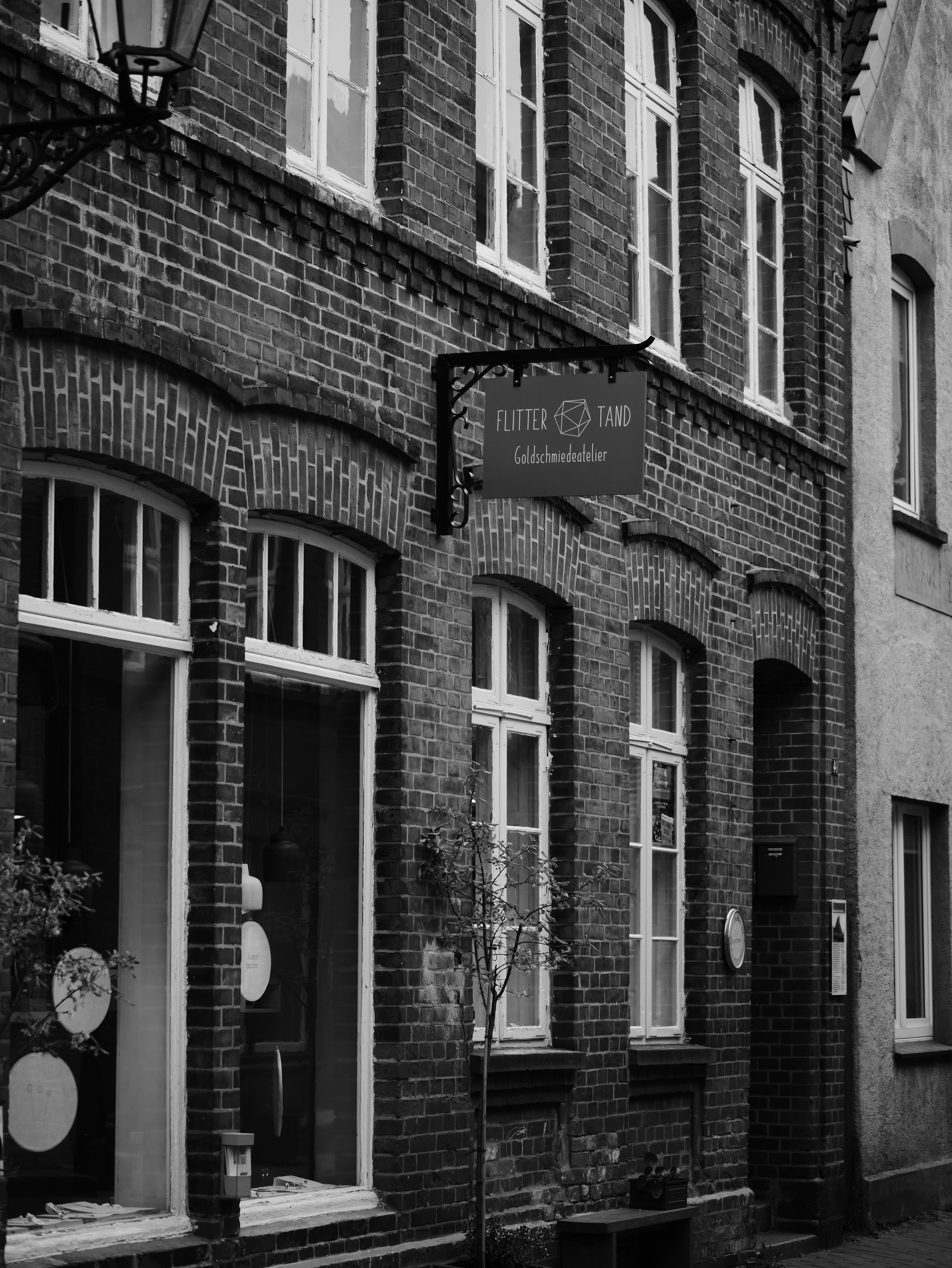 Black and white photo of a historic brick building showcasing a shop facade.