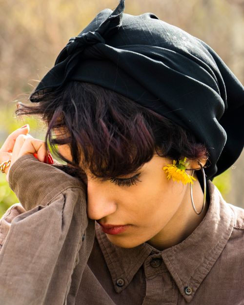 Free Middle Eastern woman in a headscarf and flower, showcasing natural beauty in an outdoor setting. Stock Photo