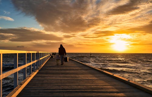 Photo of People on Wooden Dock During Sunset