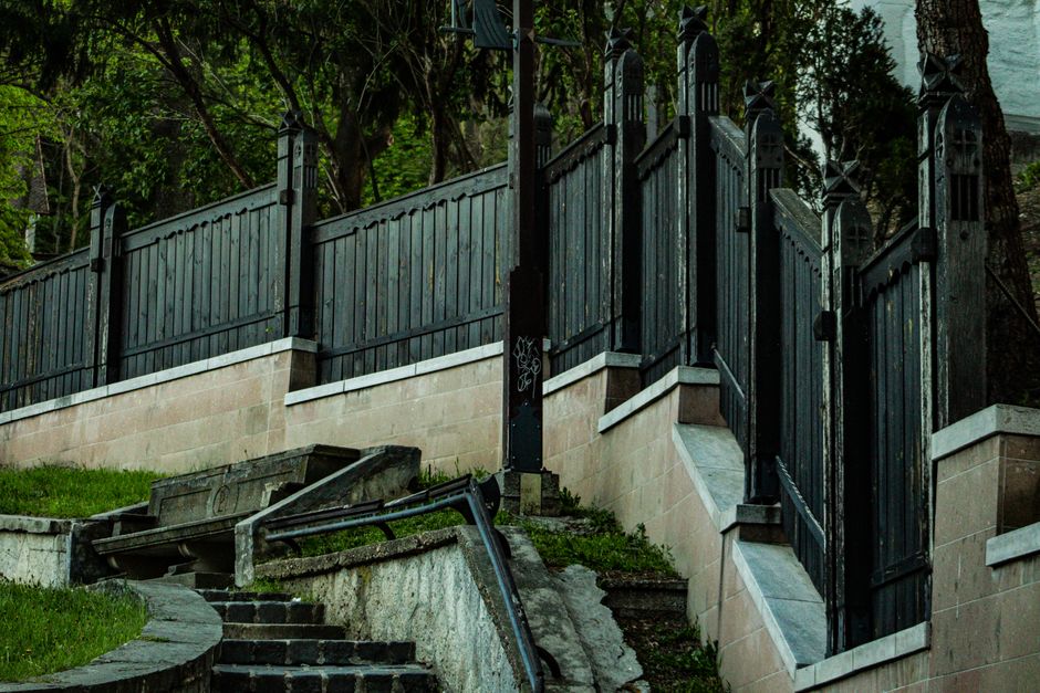 Fotomural Vallas de madera y escalera de piedra en un entorno exterior exuberante en Miskolc, Hungría.