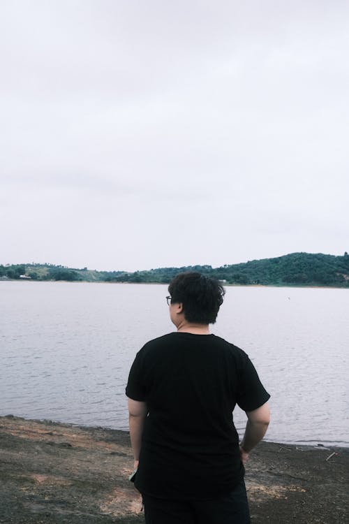 Free Back View Shot of a Man in Black Crew Neck T-shirt Standing the Lake Stock Photo