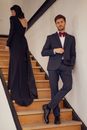 Handsome  man. boutique Jaket italy style stylish interior meeting woman in black dress