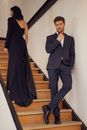 Handsome  man. boutique Jaket italy style stylish interior meeting woman in black dress