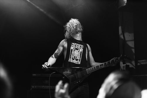Free A powerful black and white image of a guitarist performing energetically on stage, creating an electrifying concert atmosphere. Stock Photo