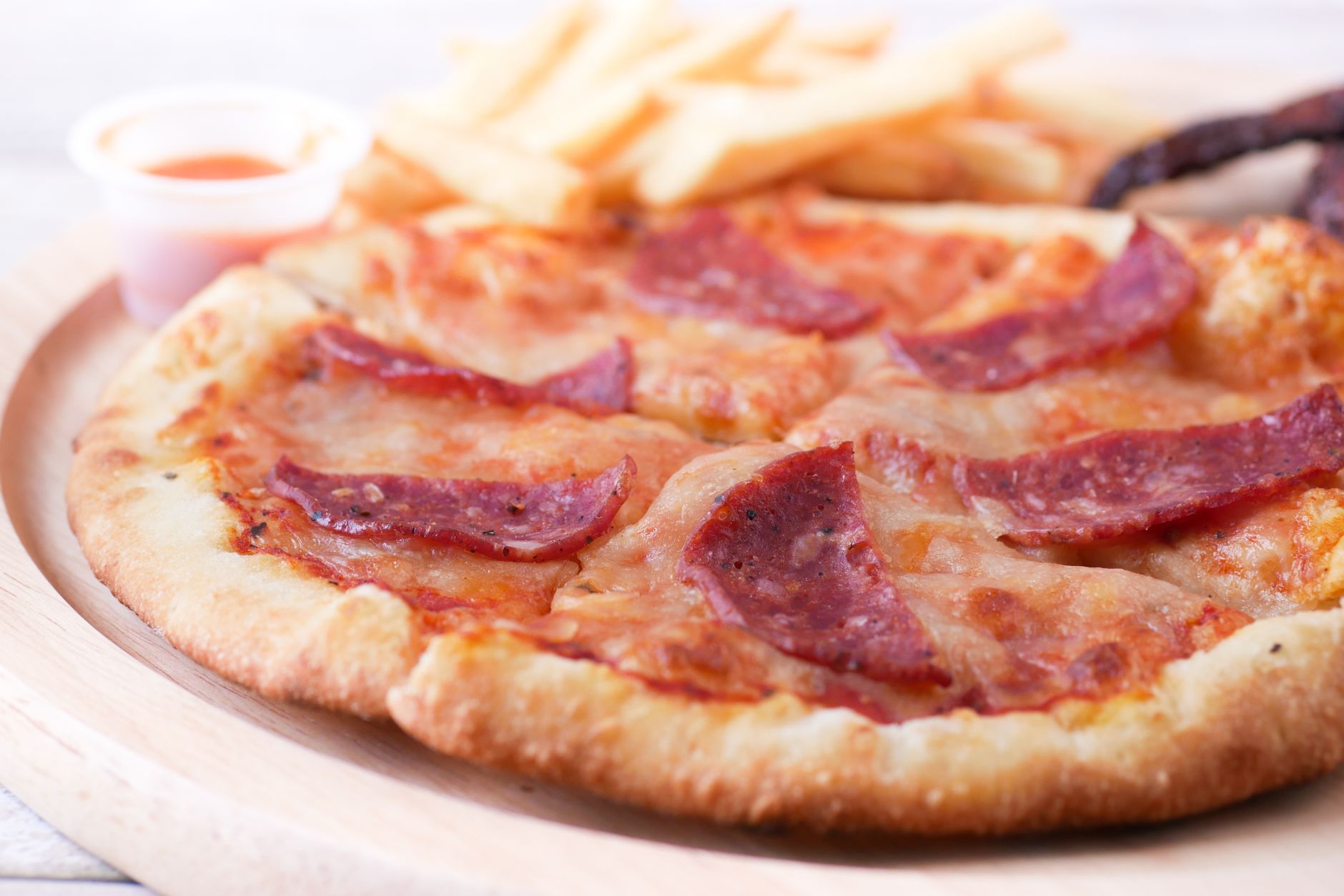 Homemade style frozen pepperoni pizza being pulled out of the oven