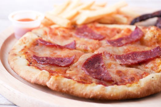 Delicious pepperoni pizza complemented with crispy fries on a wooden plate. Perfect for food photography.