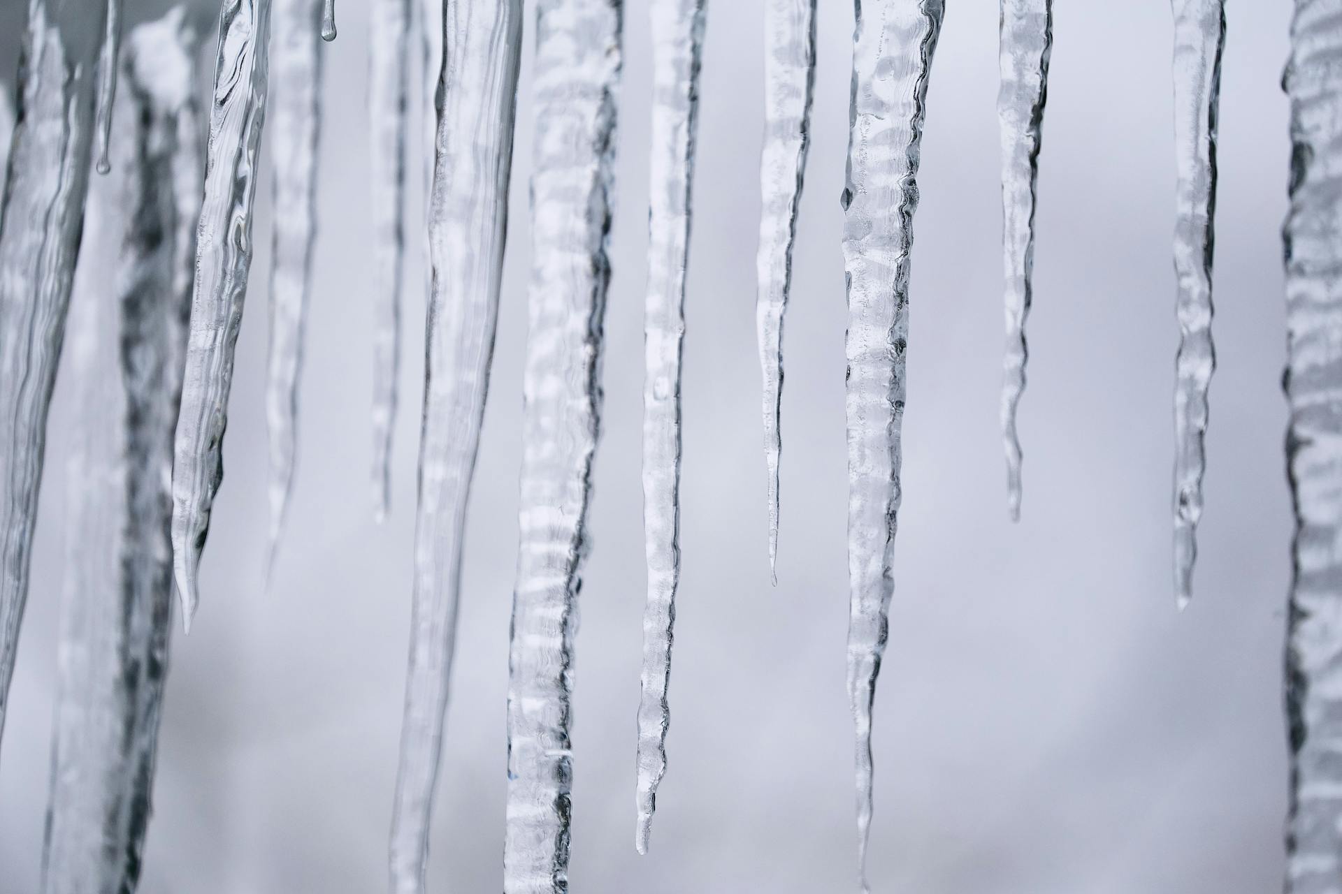 Detailed view of icicles forming during a cold winter day, showcasing nature's beauty.