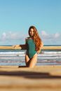 Woman Posing on a Beach in a Green Swimming Costume 