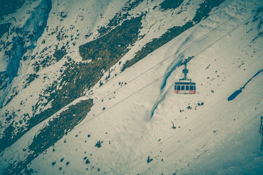 Elevated view of a cable car traversing a snow-covered mountain slope, evoking a sense of adventure.