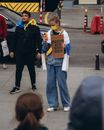 Woman in Black Jacket Holding Orange and White Book